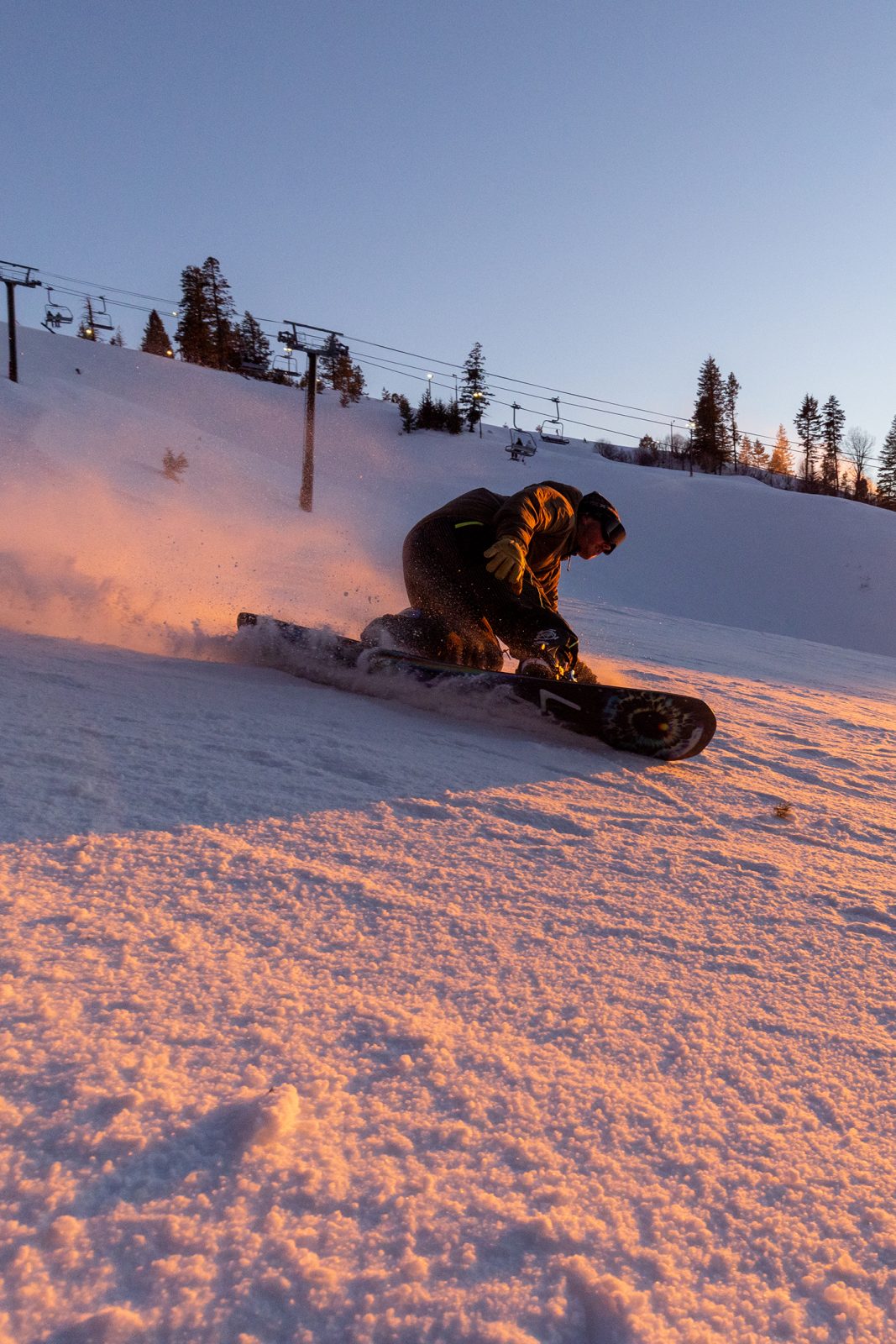 Sunset shot of snowboarder carving